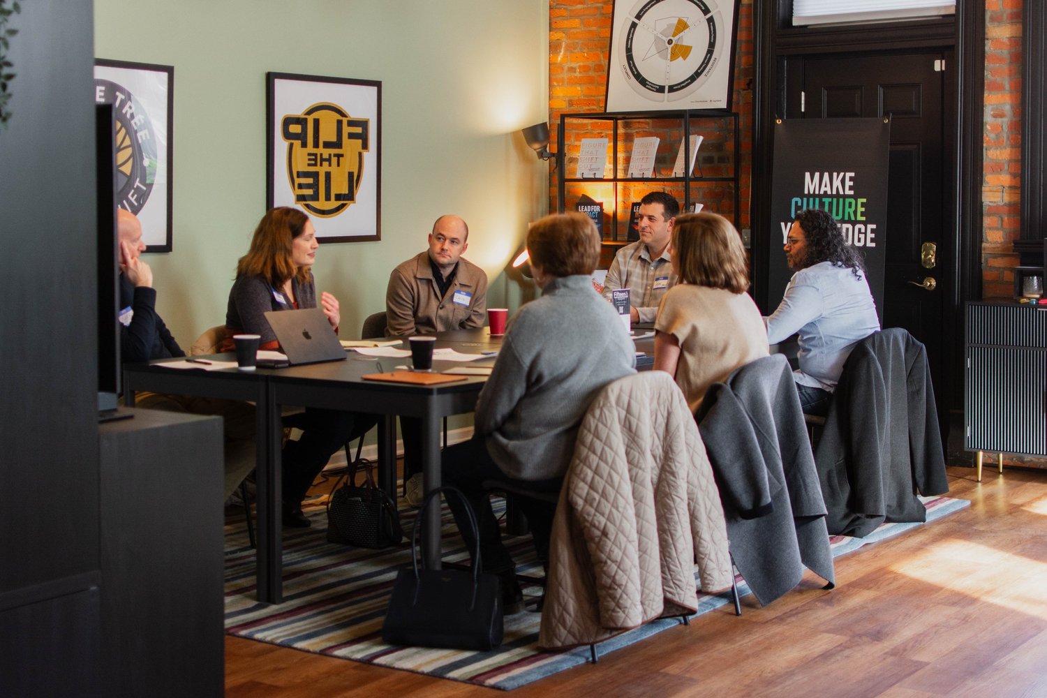 A small group sitting together in conversation around a table.