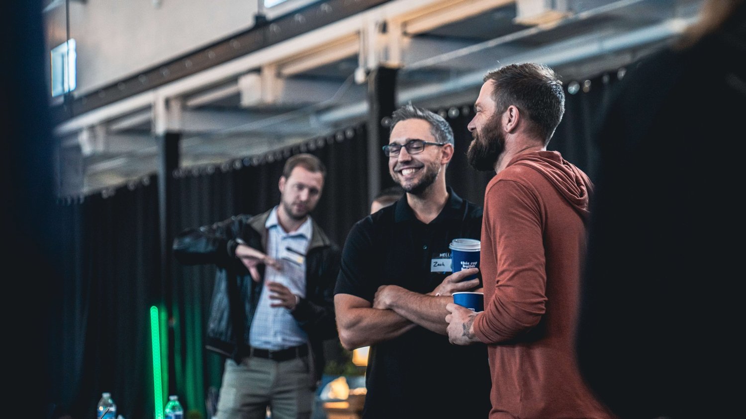 Two leaders talking and laughing over coffee at a Fifteen& gathering.